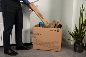 Homme déposant un toner usager dans un carton ecobox