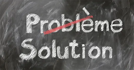 Les mots "problème" et "solution" écrit à la craie. Le mot "problème" est barré.